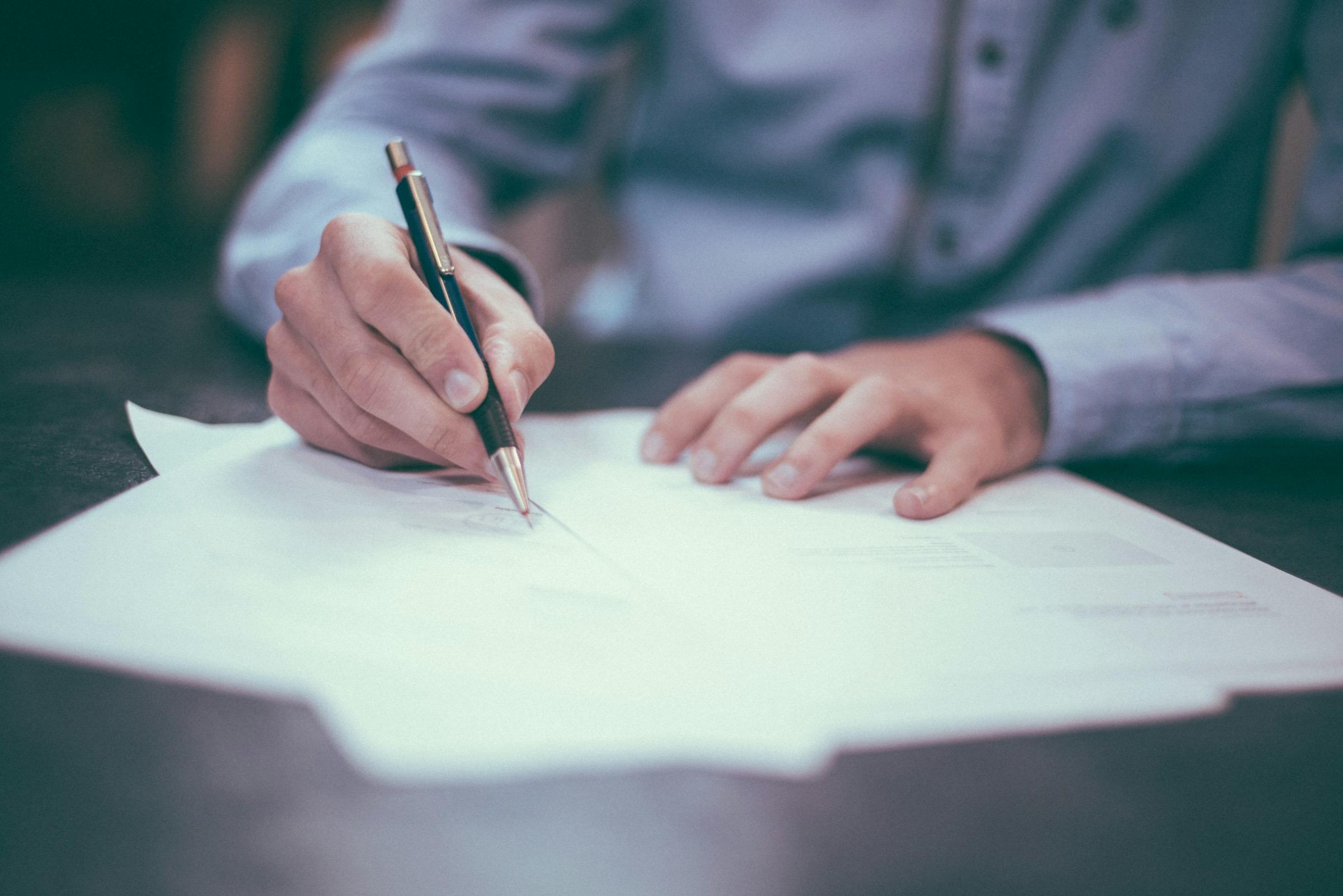 A banker reviewing and signing loan paperwork